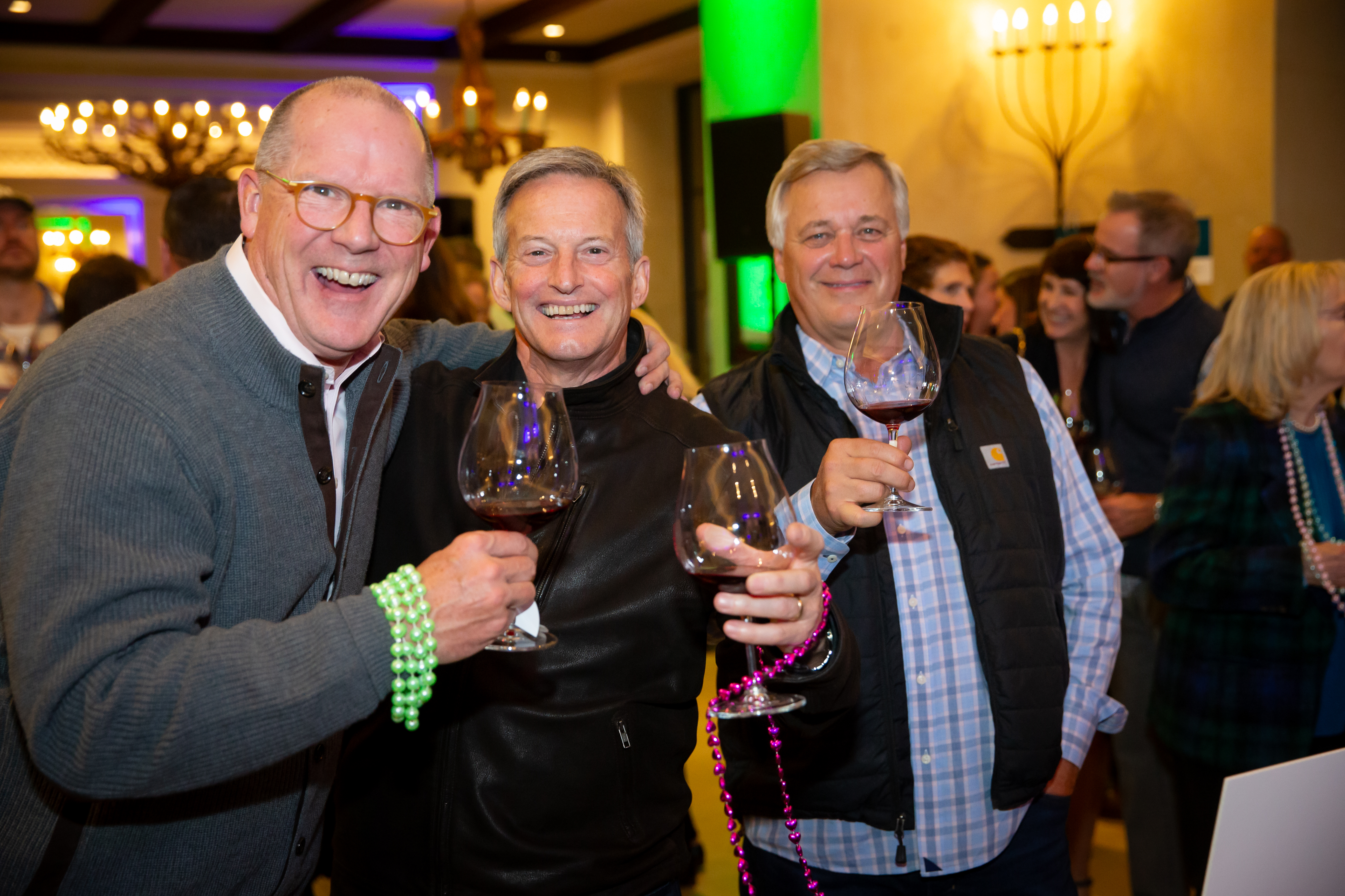 people posing with wine glasses during a party