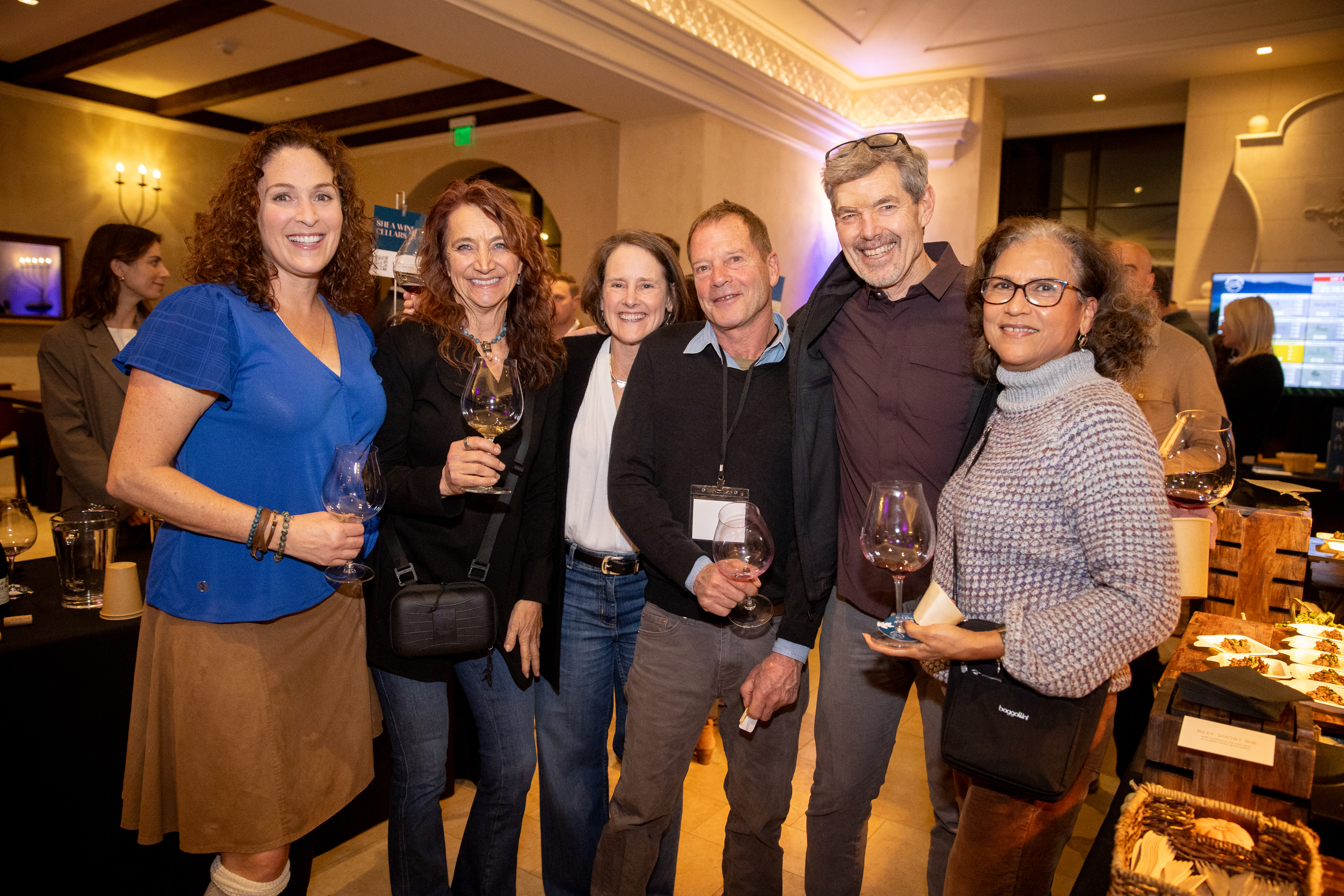 people posing together at a wine event